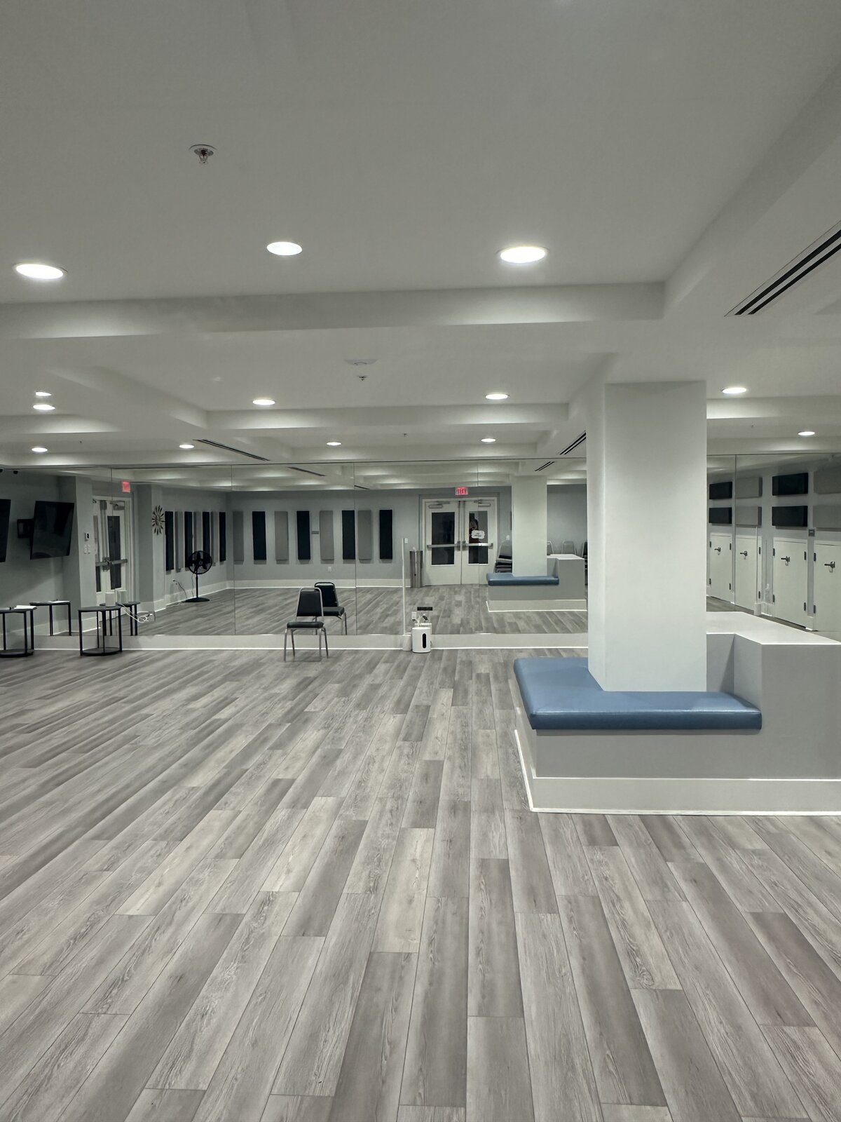 Mirrored dance and fitness studio with polished wood-look floors