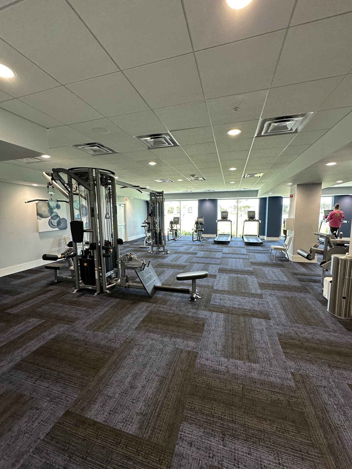 Fitness center with cleaned carpet tiles and wiped-down cardio equipment