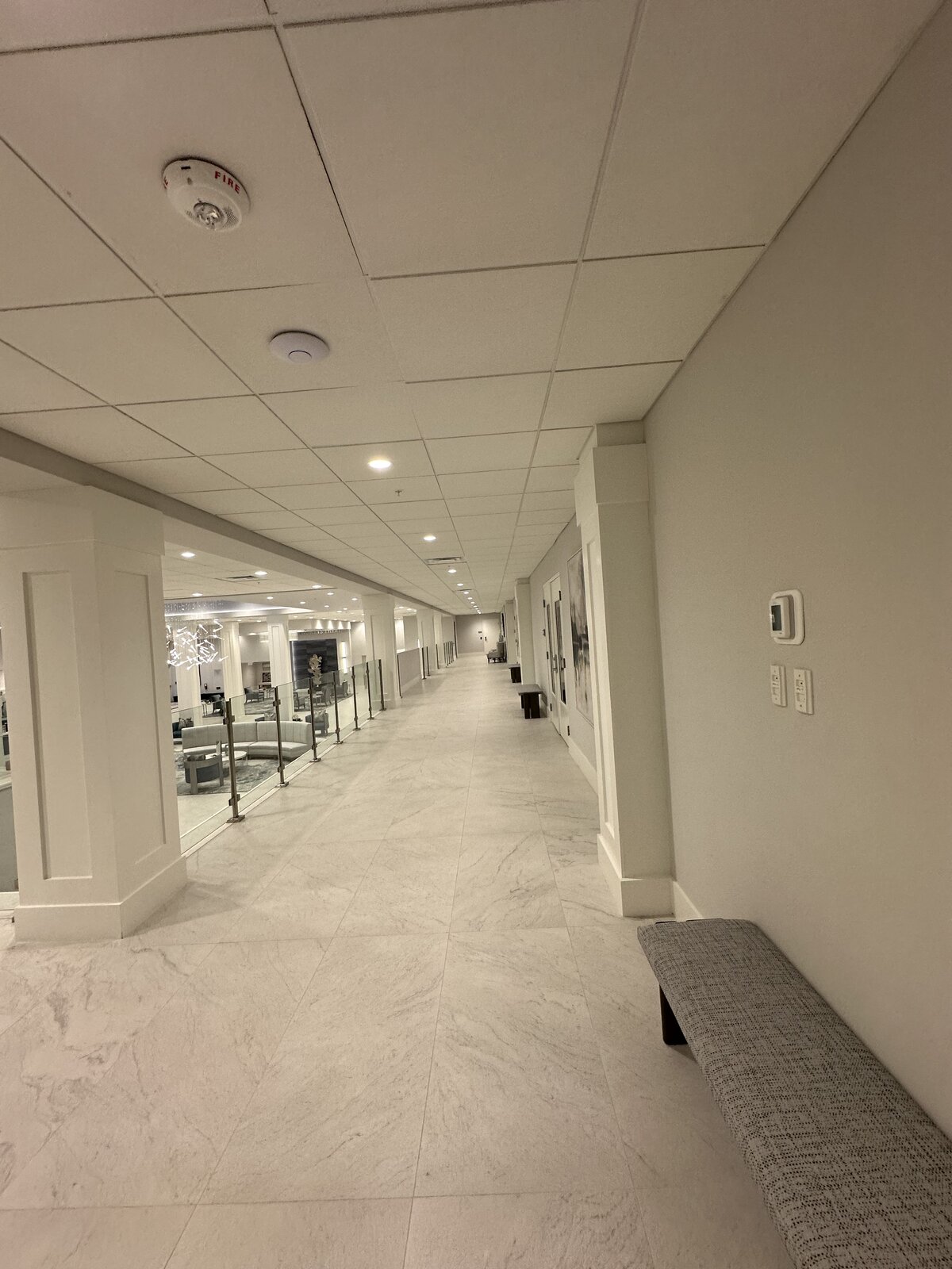 Marble corridor with polished tile floors and clean glass railings