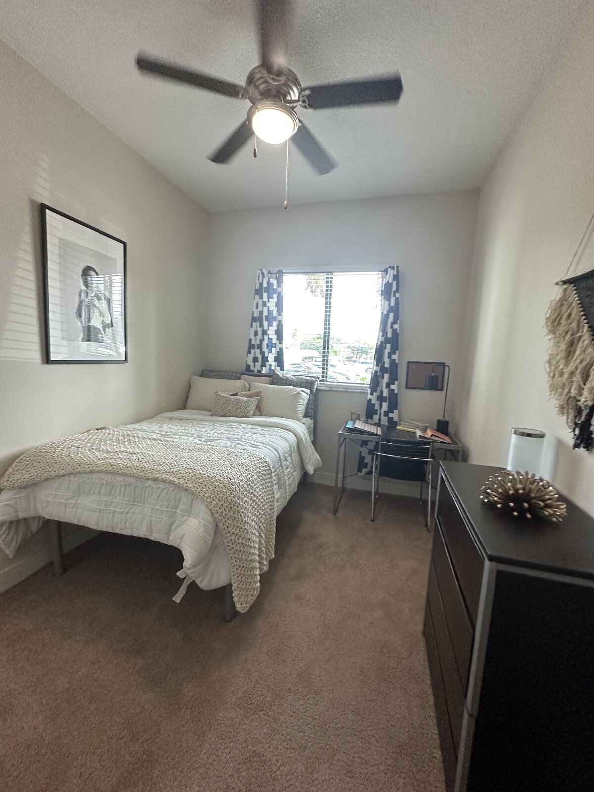 Cleaned college dorm room with neatly made bed, desk and dresser