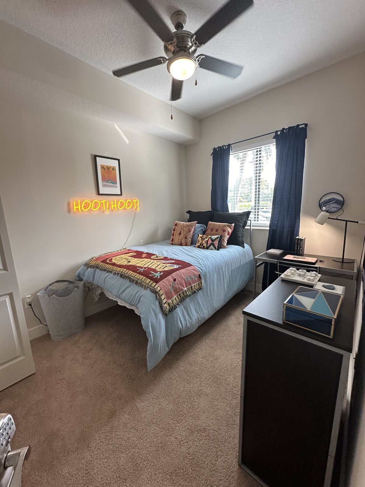 Freshly turned dorm room with styled bedding and tidy desk area