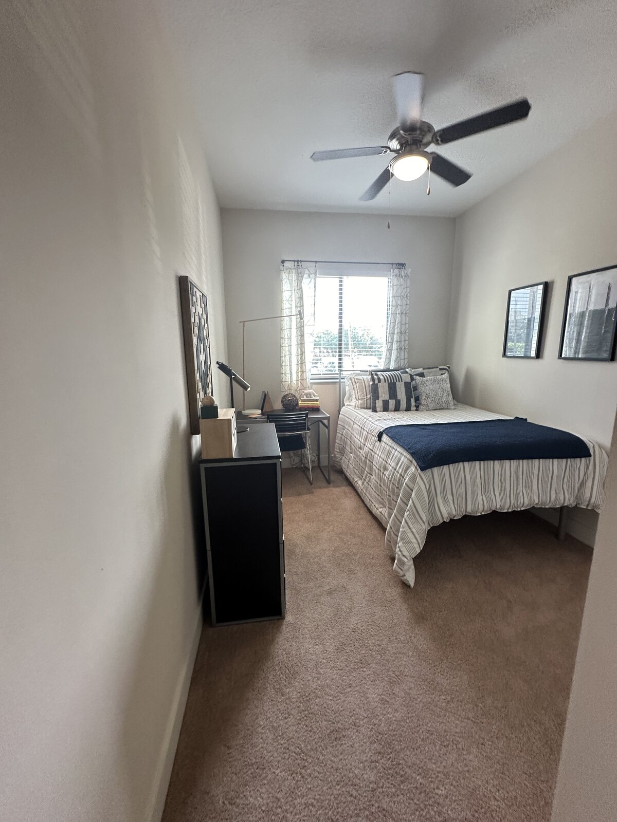 Bright dorm room with made bed, clean window and spotless floors
