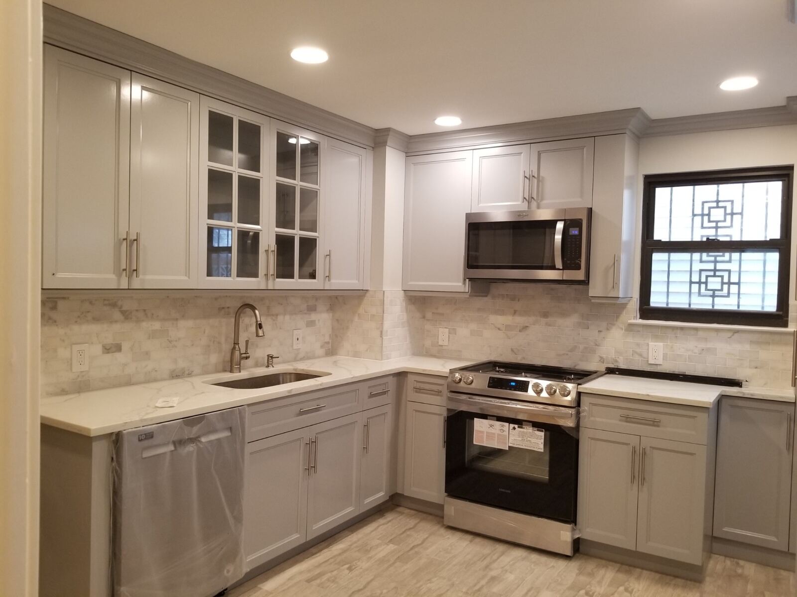 Bright shaker-style kitchen with sparkling appliances and tile backsplash
