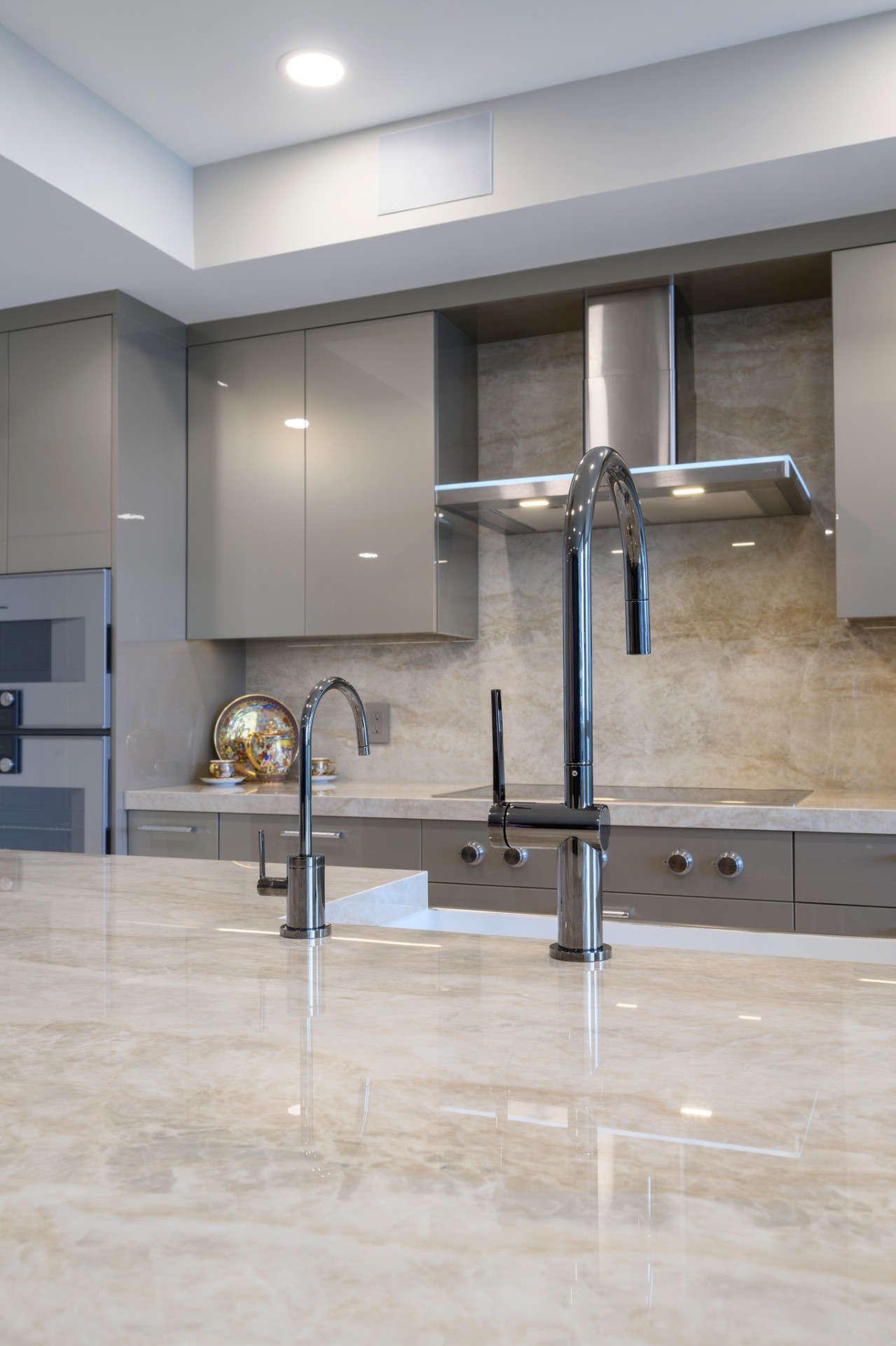 Modern kitchen with polished stone countertops and stainless fixtures